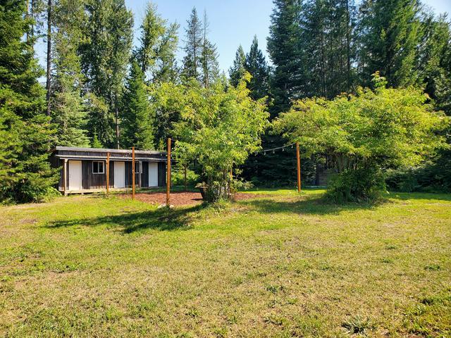 The cedar bunkhouse with three white doors on the quiet clearing