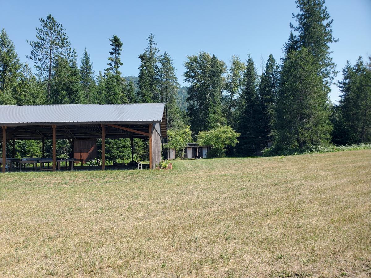 View from the high meadow: the pavilion looks through to the cabins at the forest edge
