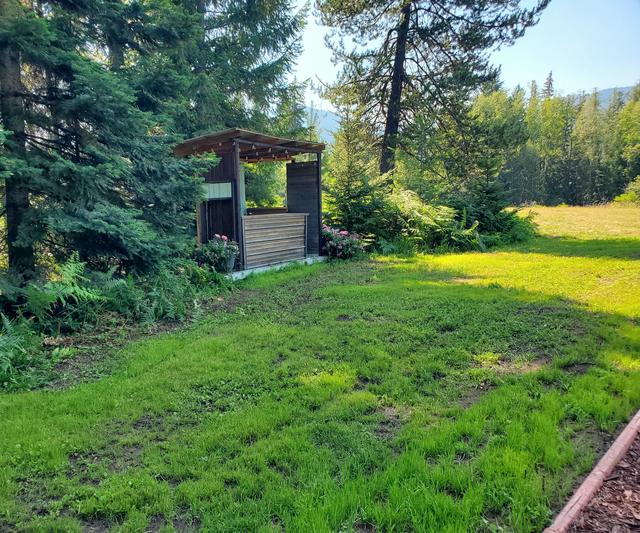 Rustic timber serving hut among conifers and pink blooms